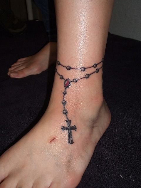 female rosary tattoo on arm