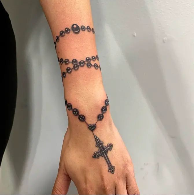 female rosary tattoo on hand